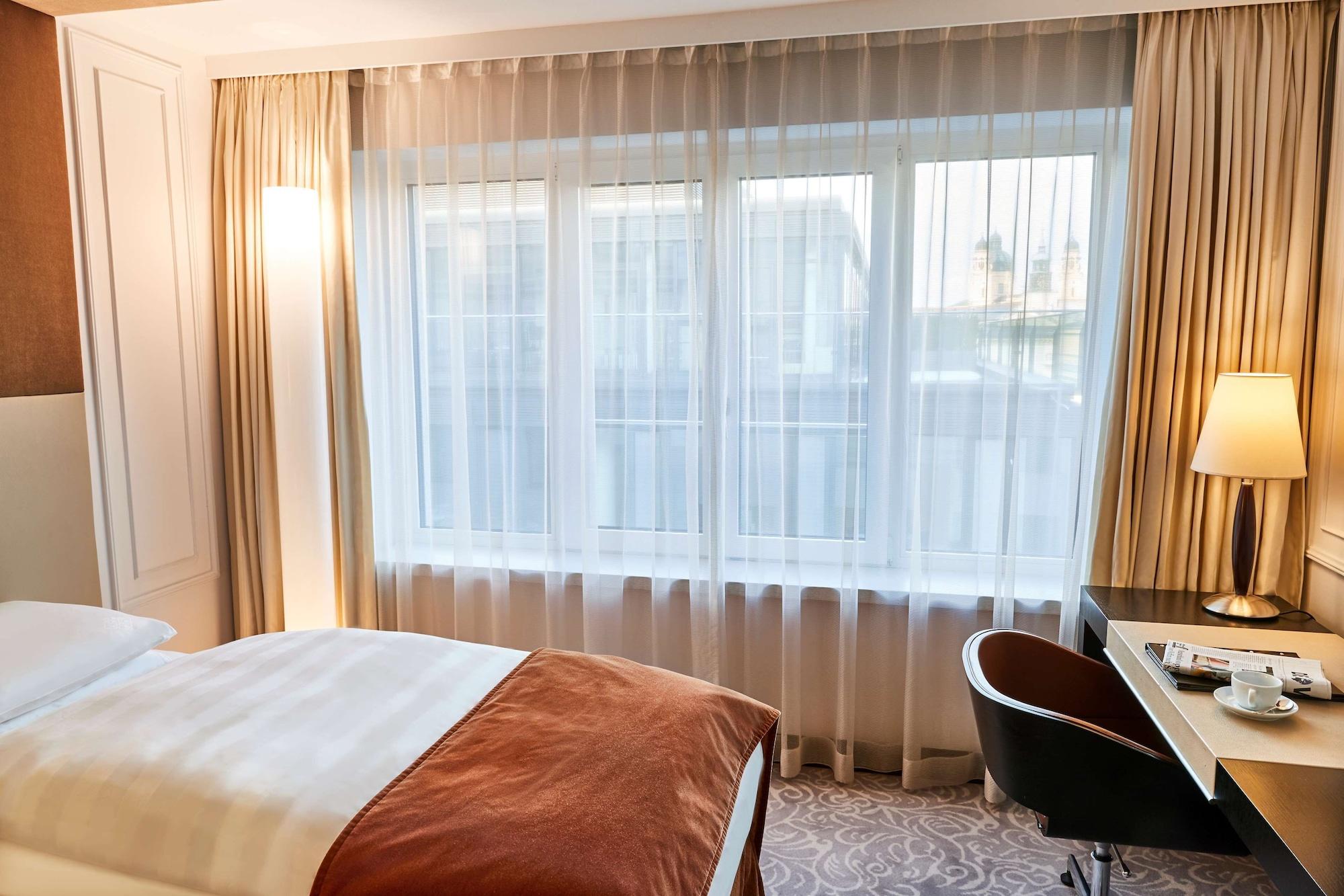 Vier Jahreszeiten Kempinski Muenchen Ngoại thất bức ảnh A bedroom with curtains
